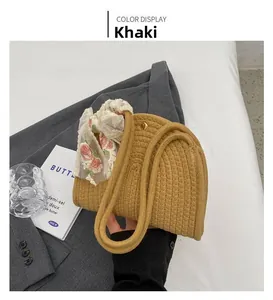 Close-up of khaki woven cotton rope handbag with floral lace scarf detail and metal buckle