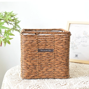 Square dark brown hand-woven rattan storage basket with a stylish leather label