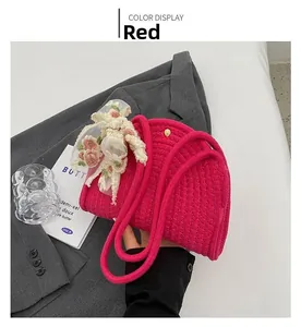 Detail of red woven cotton rope bag with floral embroidery and lace ribbon on a blazer