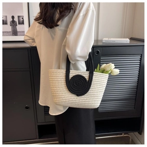 Close-up of woven tote bag featuring black circular detail and beige cotton cord texture