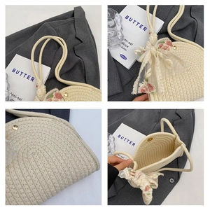 Detail of beige woven shoulder bag with floral lace bow and magnetic snap closure