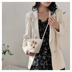 Détail du mini sac seau tressé à la main avec appliques florales 3D pour l'été
