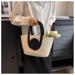 Close-up of beige and black woven tote bag detailing the dense cotton rope texture