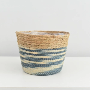 Detailed texture of hand-woven grass flower pot with waterproof lining and blue stripes