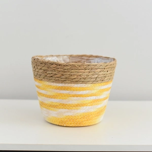 Detailed close-up of handmade woven straw planter with yellow and white striped patterns