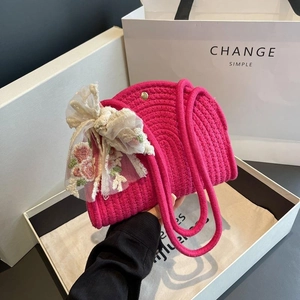 Magenta woven cotton rope shoulder bag featuring a large floral lace bow for beach vacation