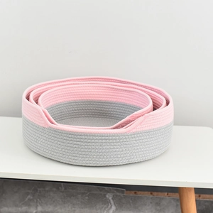 Détail de paniers gigognes ronds en corde de coton tressé dans les tons rose et gris