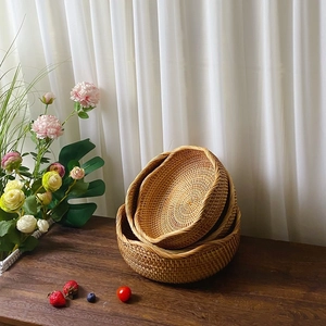 Driedelige set ronde rotan opbergmanden op een rustieke houten tafel voor in huis