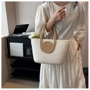 Detail of woven cotton tote bag with round pattern decoration held by a model