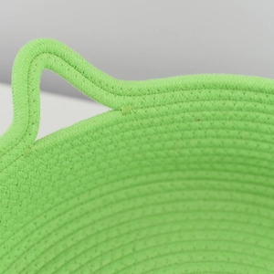 Detail of woven green cat bed featuring reinforced handles and sturdy cotton rope texture