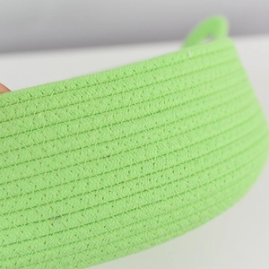 Macro shot showing woven cotton rope texture and green basket handle detail