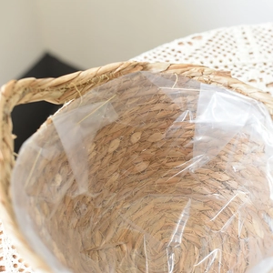Close-up of seagrass planter basket with waterproof plastic lining and spiral weaving detail