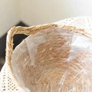Close-up of seagrass woven planter basket with waterproof plastic lining and handles