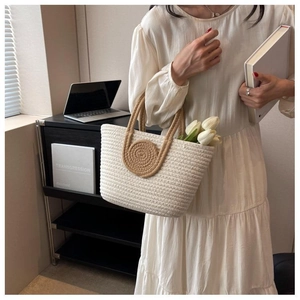 Detailed close-up of woven tote bag texture with elegant knot handles and tulip accents