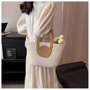 Detail view of woven cotton tote bag with round handles and white tulip decoration