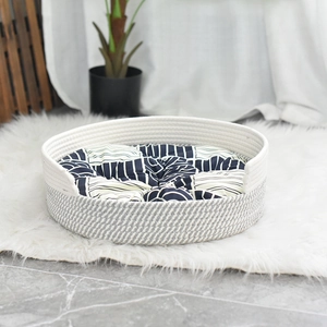 Panier pour chat tissé en coton avec coussin géométrique sur un tapis en fausse fourrure