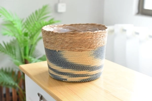Detail of handwoven seagrass flower pot with dual-color geometric pattern and natural texture