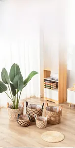 Detailed view of woven seagrass plant baskets with leather handles and black grid rope