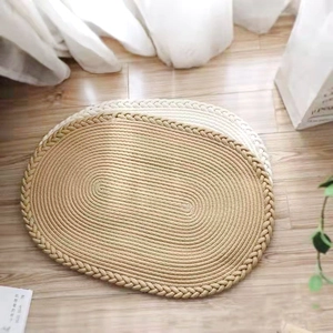 Détail d'un tapis ovale en coton tissé main montrant la texture beige et crème