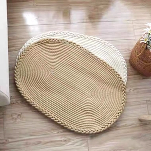 Détail d'un tapis ovale tissé main en coton avec texture en spirale et bordure décorative