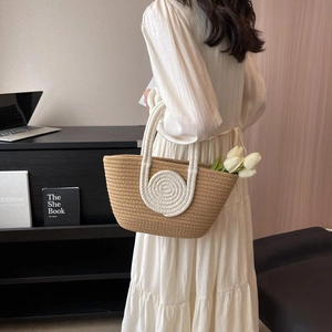 Elegant woven tote bag with white circular handles and natural straw texture for women