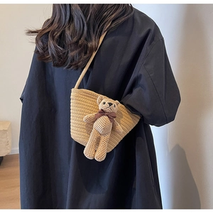Détail du sac bandoulière tissé kaki avec un joli pendentif ours en peluche fait main