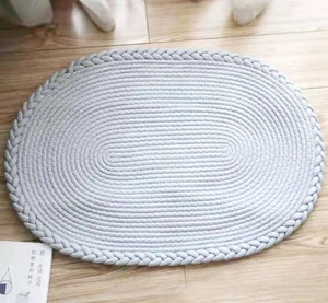 Vue détaillée de la texture et du bord tressé du tapis ovale bleu clair fait main