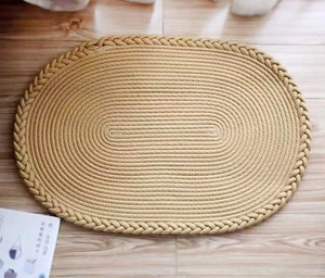 Gros plan d'un tapis de sol ovale tissé main en coton avec bordures tressées au sol