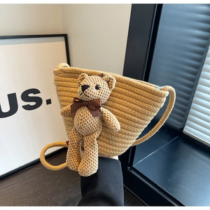Gros plan détaillé d'un sac seau en paille tissée orné d'un adorable ours en peluche