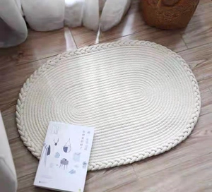 Détail d'un tapis en coton ovale tissé main avec bordure tressée sur parquet
