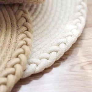 Détail de sets de table ronds tissés main montrant des bords tressés épais et naturels