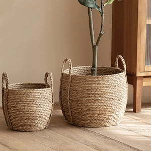 Set of two seagrass woven storage baskets with handles in a natural Nordic home setting