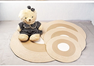 Detail of round woven cotton rope mats in white, tan, and beige with natural fiber texture