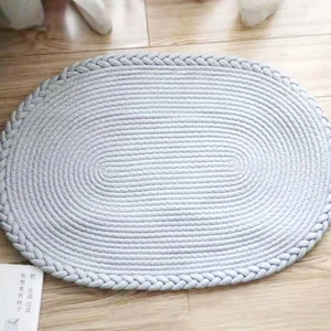 Tapis ovale en corde de coton bleu clair tissé à la main sur un parquet en bois clair