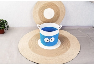 Detail of blue and white cotton rope woven storage basket with cartoon eye design