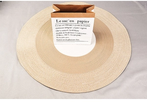 Detailed top view of a handmade round cotton rope rug with beige and white woven pattern