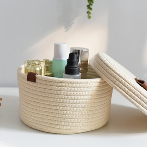 Close-up of cotton rope woven storage basket with lid and brown leather handles