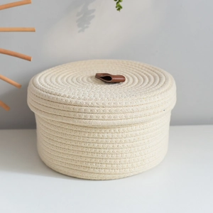 Close-up of woven cotton rope storage basket with lid and brown leather handle