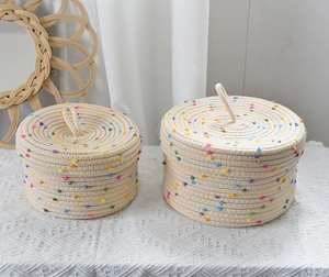 Detailed macro view of woven cotton storage baskets with colorful dots and matching lids