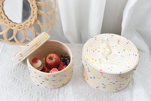 Detail of hand-woven cotton rope baskets with colorful pom-poms and matching lids