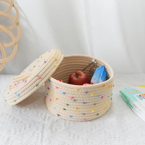 Macro detail of hand-woven cotton storage basket with colorful dots and matching lid