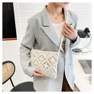 Détail de la texture en coton tissé blanc avec nœuds et pompons sur le sac à main