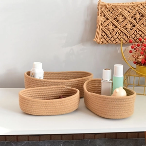 Three-piece oval woven cotton rope storage baskets in natural brown for home organization