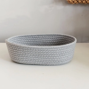 Macro shot of oval woven cotton rope storage basket with detailed gray fabric texture