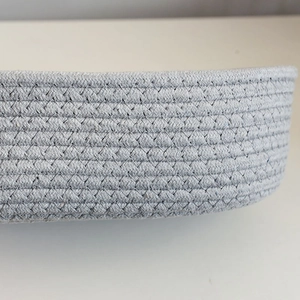Macro shot of gray woven cotton rope storage basket showing detailed geometric texture