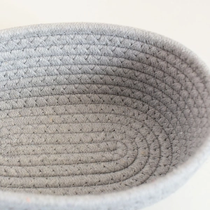 Close-up detail of grey woven cotton rope basket showing intricate stitching and texture