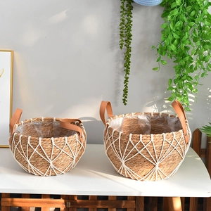 Detail of woven rattan plant pots with waterproof liners and brown leather handles