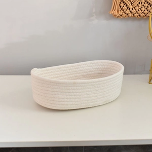 Close-up of handwoven white cotton rope storage basket with thick spiral weave texture