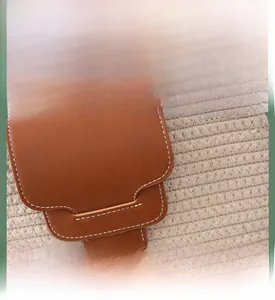 Detail of premium brown leather stitching and hand-woven textured fiber fabric