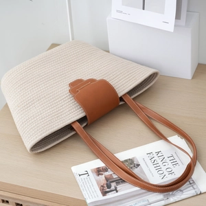Minimalist woven cotton rope tote bag with brown leather straps for beach vacations